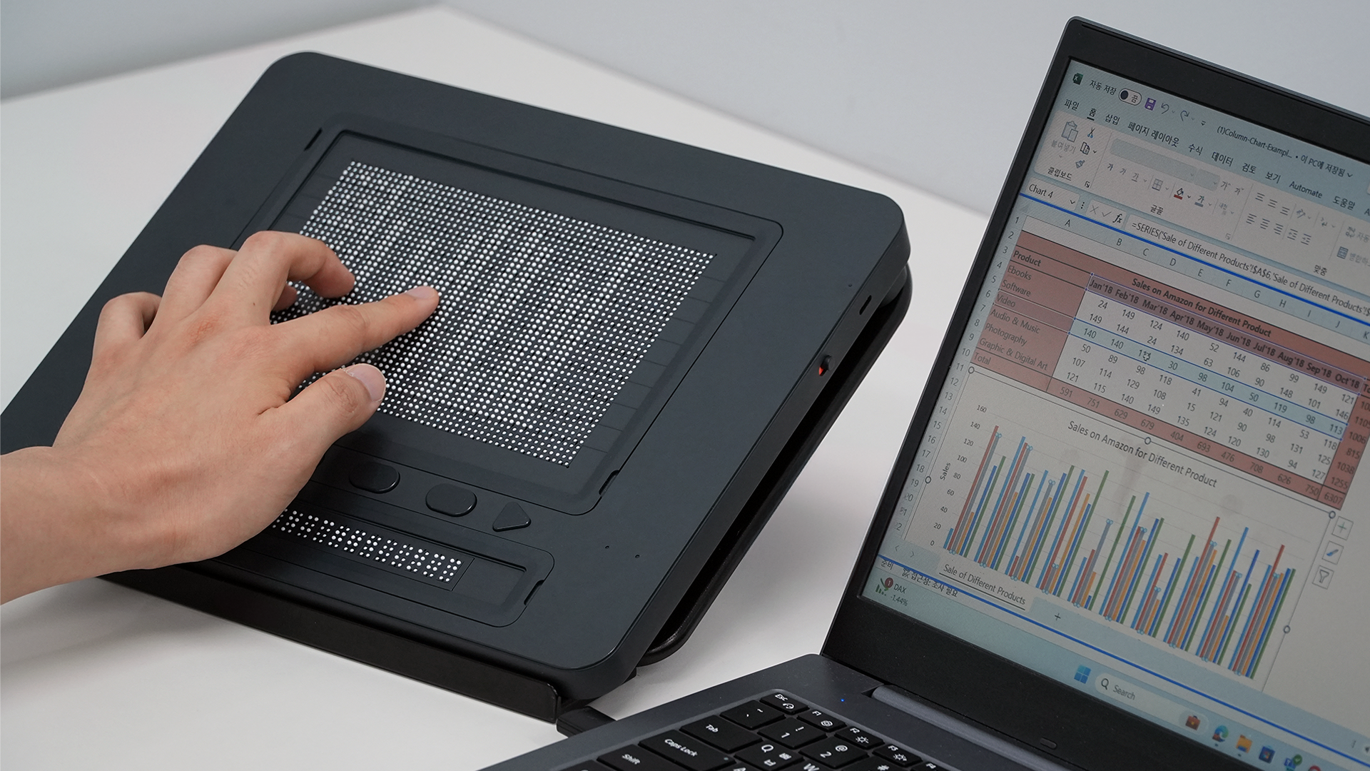 The Dot Pad X is being used to display a tactile image of a graph from a laptop that is paired to it
